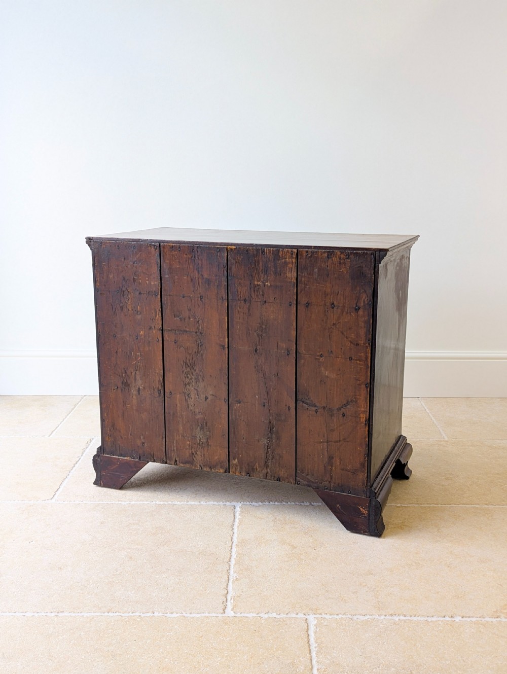 An antique George II mahogany chest of drawers featuring four graduated drawers with ornate brass handles on bracket feet. View XIX