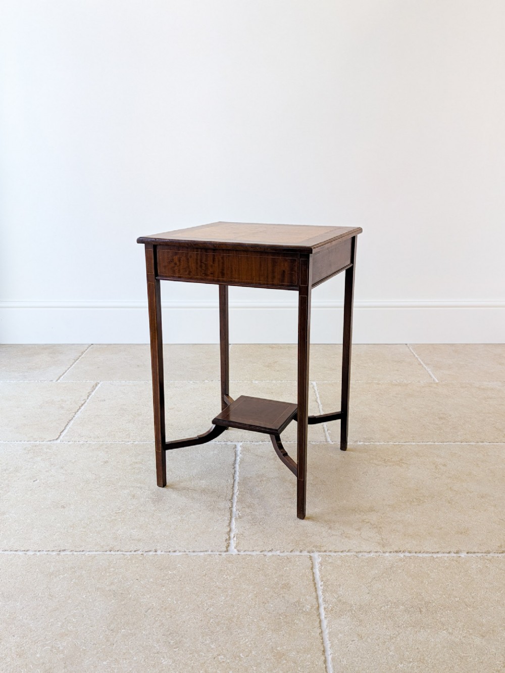 A late 18th-century George III square occasional table crafted from dark mahogany with a burr yew inlaid top, tapered legs, and a lower square undertier.