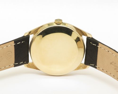 fig 5. A vintage 1960s IWC wristwatch featuring a solid gold case, a black dial with gold baton hour markers, and a black leather strap.