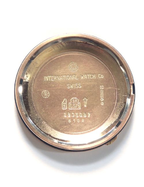 A vintage 1960s IWC wristwatch featuring a solid gold case, a black dial with gold baton hour markers, and a black leather strap. View VIII