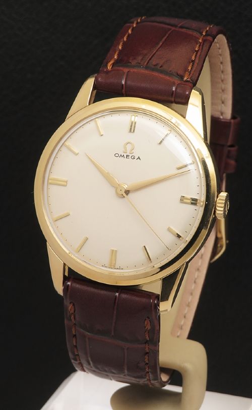 fig 1. A 1960s Omega wristwatch featuring a gold-filled case, a cream dial with gold baton hour markers, and a brown leather strap.