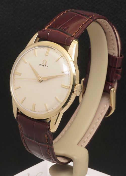 fig 2. A 1960s Omega wristwatch featuring a gold-filled case, a cream dial with gold baton hour markers, and a brown leather strap.