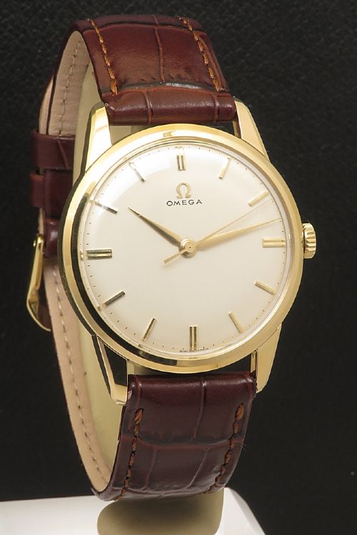 fig 3. A 1960s Omega wristwatch featuring a gold-filled case, a cream dial with gold baton hour markers, and a brown leather strap.