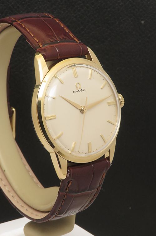 fig 4. A 1960s Omega wristwatch featuring a gold-filled case, a cream dial with gold baton hour markers, and a brown leather strap.