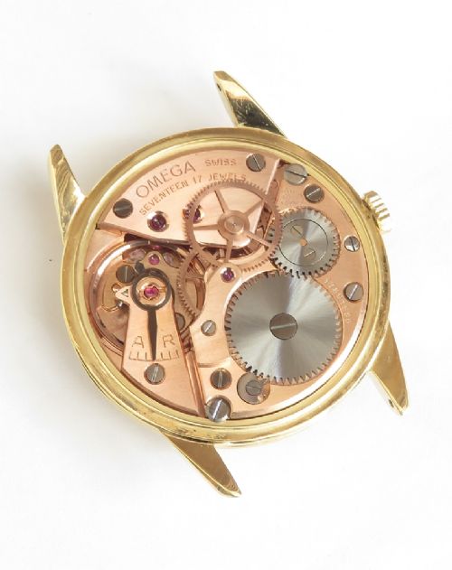 A 1960s Omega wristwatch featuring a gold-filled case, a cream dial with gold baton hour markers, and a brown leather strap. View VII