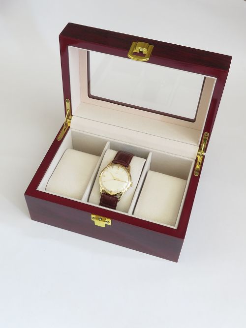 A 1960s Omega wristwatch featuring a gold-filled case, a cream dial with gold baton hour markers, and a brown leather strap. View IX