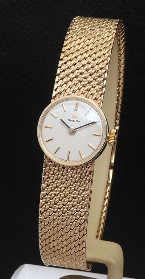 fig 1. A 1967 Omega ladies wristwatch featuring a round white dial with gold baton markers and an integrated woven 9ct gold bracelet.