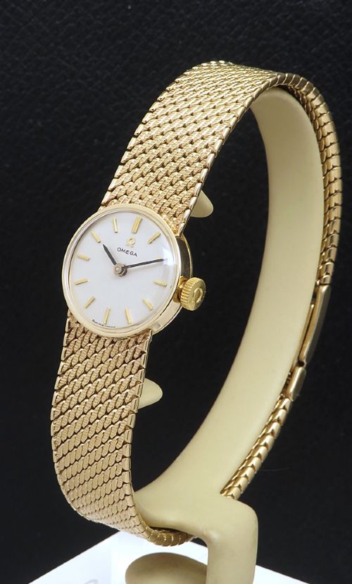 fig 2. A 1967 Omega ladies wristwatch featuring a round white dial with gold baton markers and an integrated woven 9ct gold bracelet.