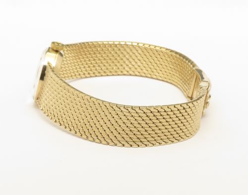 fig 6. A 1967 Omega ladies wristwatch featuring a round white dial with gold baton markers and an integrated woven 9ct gold bracelet.