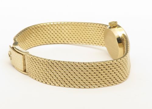 A 1967 Omega ladies wristwatch featuring a round white dial with gold baton markers and an integrated woven 9ct gold bracelet. View VIII