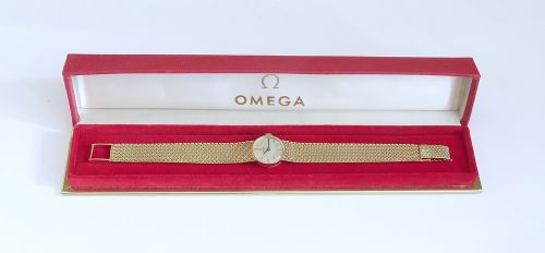 A 1967 Omega ladies wristwatch featuring a round white dial with gold baton markers and an integrated woven 9ct gold bracelet. View XI