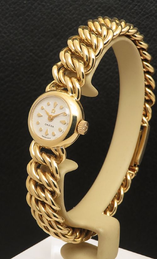 fig 2. A vintage 18ct yellow gold ladies Omega wristwatch featuring a textured white dial and an integrated rope twist gold bracelet.