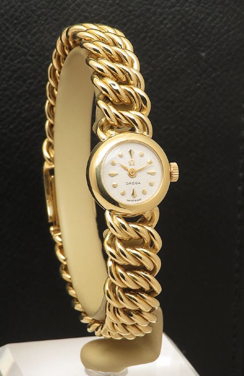fig 3. A vintage 18ct yellow gold ladies Omega wristwatch featuring a textured white dial and an integrated rope twist gold bracelet.