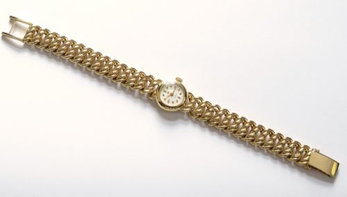 fig 5. A vintage 18ct yellow gold ladies Omega wristwatch featuring a textured white dial and an integrated rope twist gold bracelet.