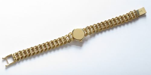 fig 6. A vintage 18ct yellow gold ladies Omega wristwatch featuring a textured white dial and an integrated rope twist gold bracelet.