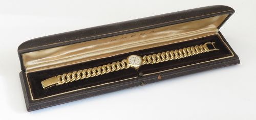 A vintage 18ct yellow gold ladies Omega wristwatch featuring a textured white dial and an integrated rope twist gold bracelet. View IX
