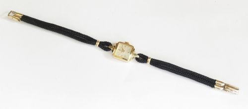 An 18ct yellow gold 1956 Omega ladies cocktail watch featuring a square white dial and black braided cord strap. View VIII