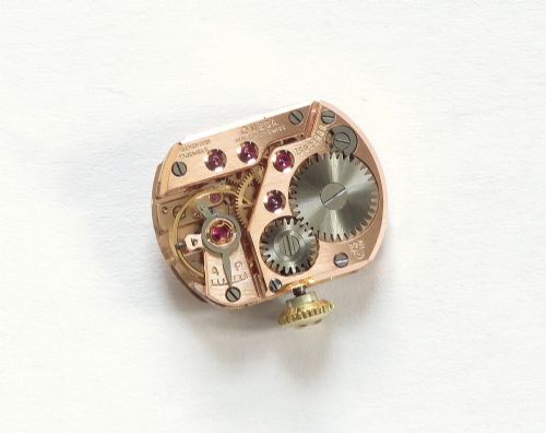 An 18ct yellow gold 1956 Omega ladies cocktail watch featuring a square white dial and black braided cord strap. View XI