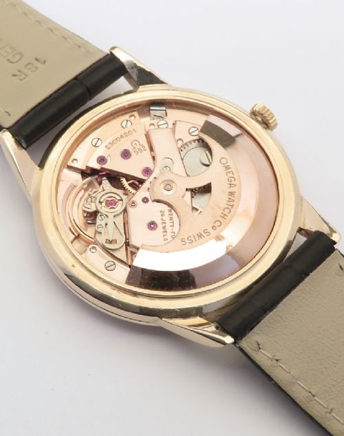 A 1967 Omega Geneve automatic wristwatch featuring a circular solid 9ct gold case, a silvered sunburst dial with gold baton hour markers, and a black leather strap. View VIII