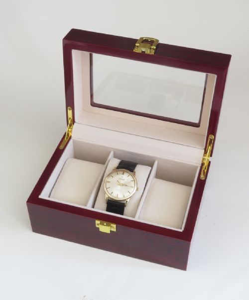 A 1967 Omega Geneve automatic wristwatch featuring a circular solid 9ct gold case, a silvered sunburst dial with gold baton hour markers, and a black leather strap. View X