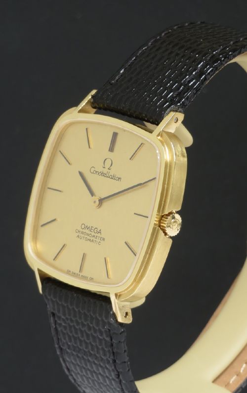 fig 4. A 1968 Omega Constellation Deluxe wristwatch featuring a cushion-shaped 18ct gold case, brushed champagne dial, baton indices, and a black textured leather strap.
