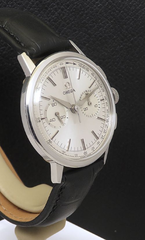 fig 4. A 1963 stainless steel Omega chronograph wristwatch featuring a silver dial with two sub-dials and a black leather strap.