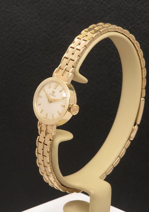 fig 1. A 1961 ladies Omega wristwatch made from solid 9ct gold featuring a round dial with baton markers and an integrated brick-link gold bracelet.