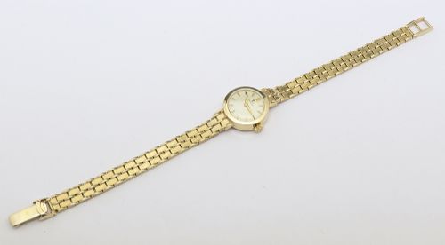 fig 3. A 1961 ladies Omega wristwatch made from solid 9ct gold featuring a round dial with baton markers and an integrated brick-link gold bracelet.