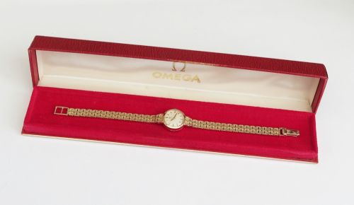 A 1961 ladies Omega wristwatch made from solid 9ct gold featuring a round dial with baton markers and an integrated brick-link gold bracelet. View IX