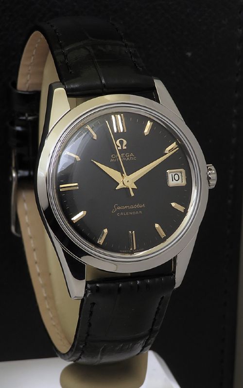 fig 2. A restored 1961 Omega Seamaster automatic wristwatch with a black dial, gold-toned hands and hour markers, date display at three oclock, and a black leather strap.