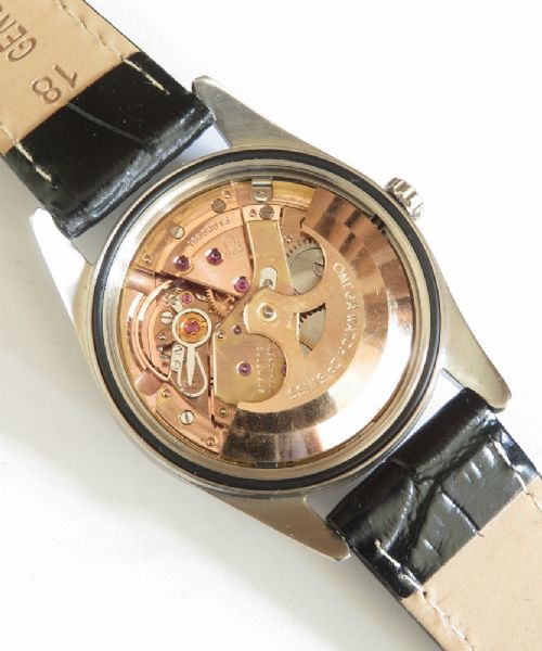 A restored 1961 Omega Seamaster automatic wristwatch with a black dial, gold-toned hands and hour markers, date display at three oclock, and a black leather strap. View VII