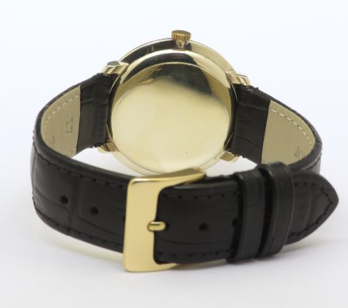 fig 4. A 1960 vintage Longines wristwatch featuring a round solid gold case, silver dial with gold markers, and a black leather strap.
