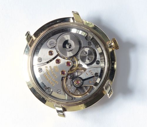 A 1960 vintage Longines wristwatch featuring a round solid gold case, silver dial with gold markers, and a black leather strap. View VI