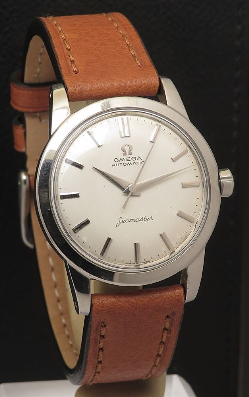 fig 2. A 1950 vintage Omega Seamaster automatic wristwatch featuring a stainless steel case, cream dial with silver index markers, and a stitched tan leather strap.