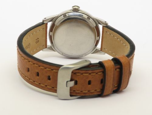 fig 4. A 1950 vintage Omega Seamaster automatic wristwatch featuring a stainless steel case, cream dial with silver index markers, and a stitched tan leather strap.