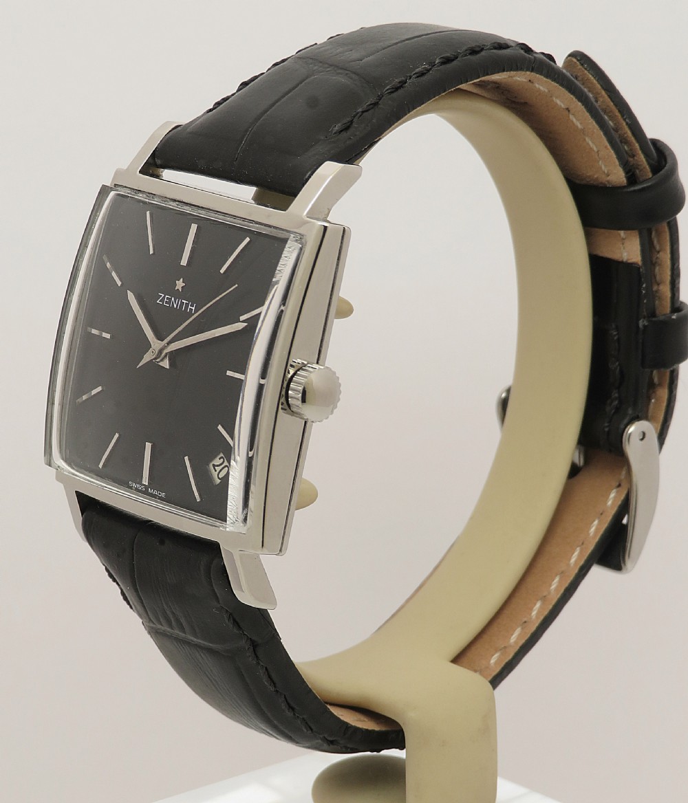 A vintage 1960s Zenith square wristwatch with a black dial, silver baton indices, date window, and a black leather strap. View VI