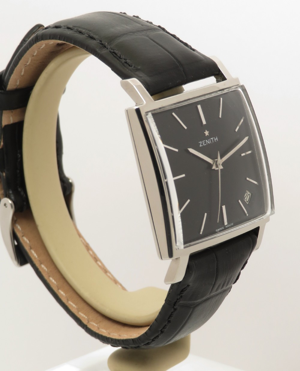 A vintage 1960s Zenith square wristwatch with a black dial, silver baton indices, date window, and a black leather strap. View VII