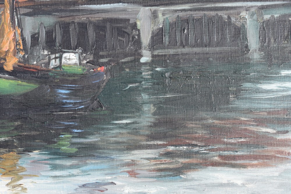 An impressionist oil painting depicting boats anchored in a French harbour against a backdrop of town buildings and a spire, set within an ornate carved frame. View VI