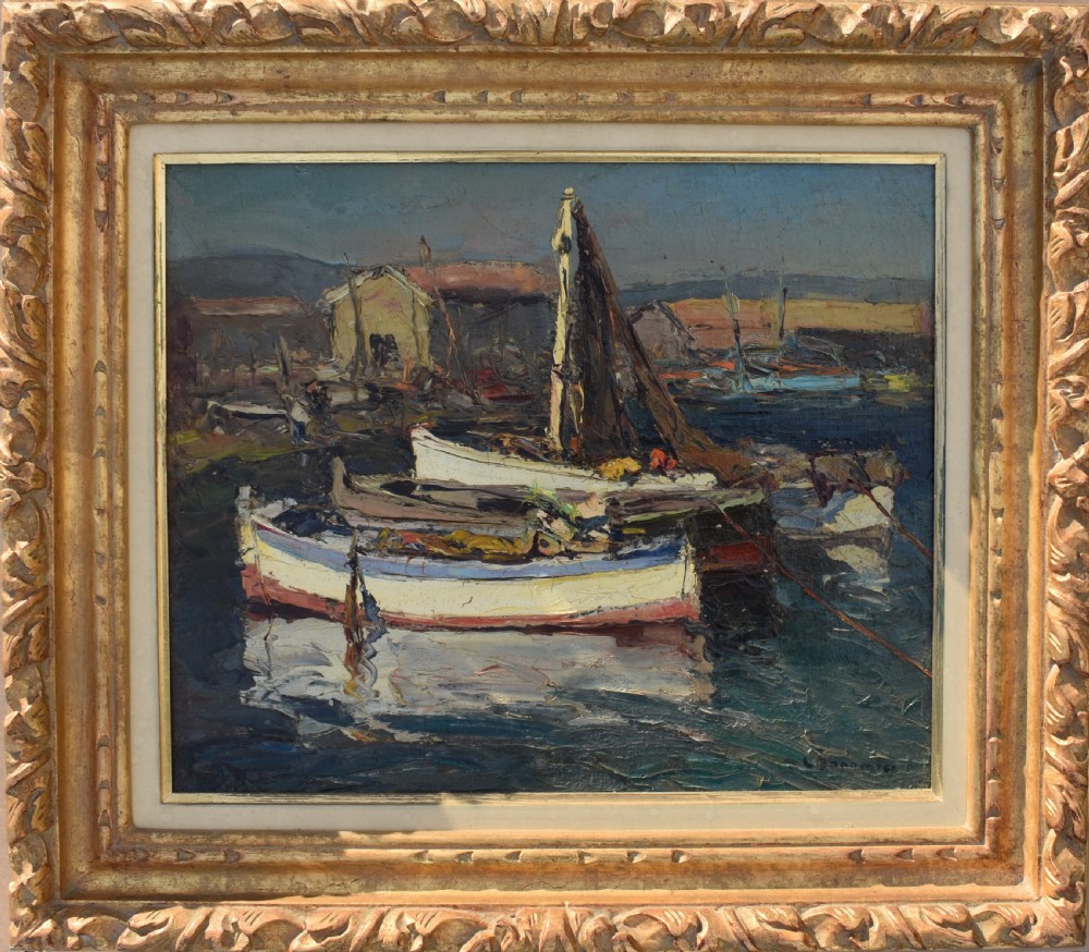A framed Post-Impressionist oil painting depicting moored fishing boats in a Mediterranean harbour, housed in a carved gilt frame with a cream inner border.