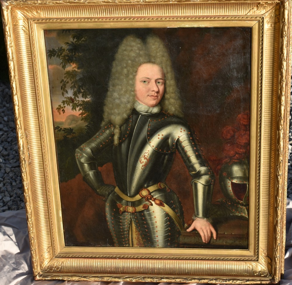 An 18th-century Baroque oil painting depicting a gentleman wearing full plate armour and a powdered wig, set within a heavily moulded giltwood frame. View VI