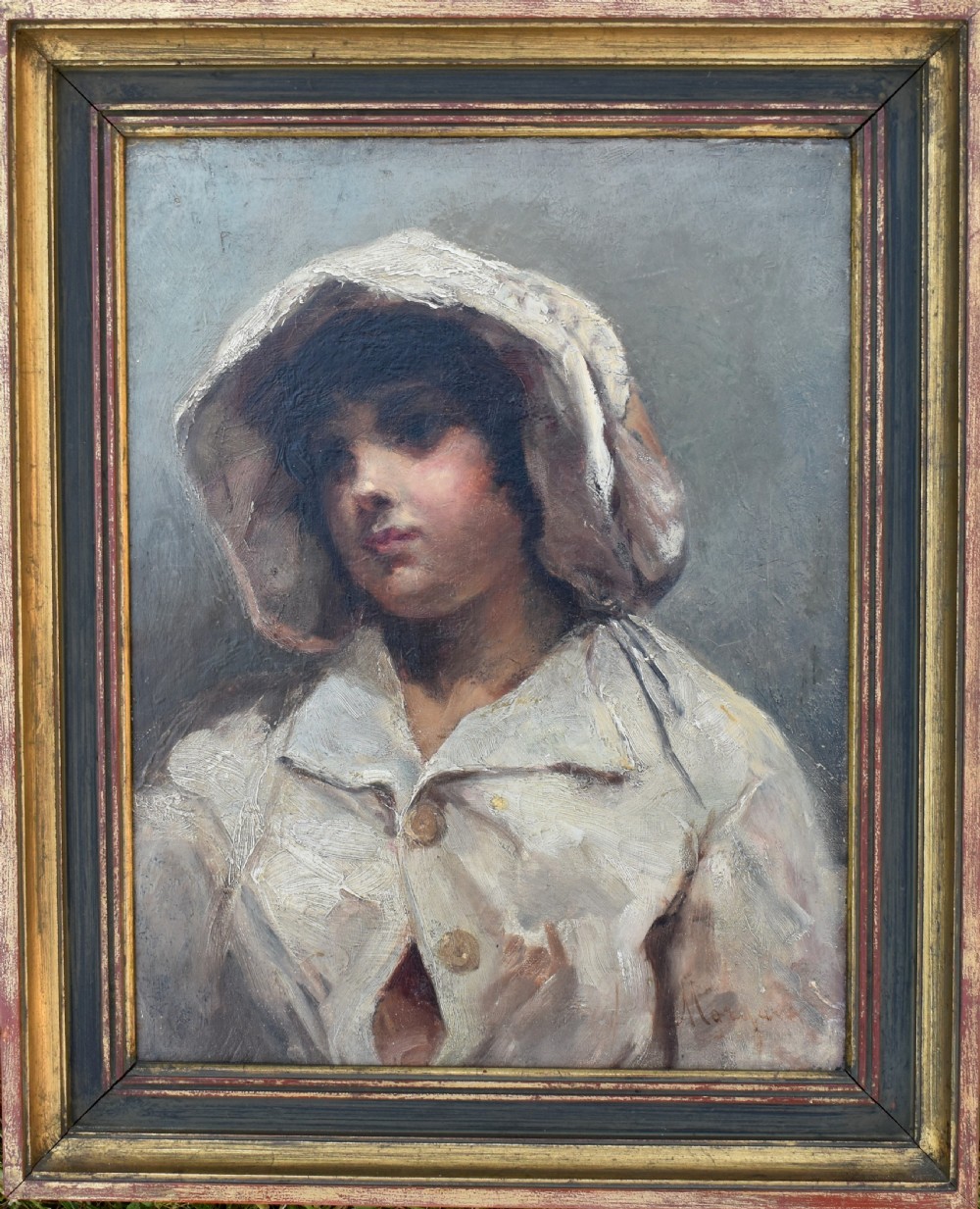 An antique oil portrait depicting a child wearing a light bonnet and coat, presented in a dark wood and gilt frame.