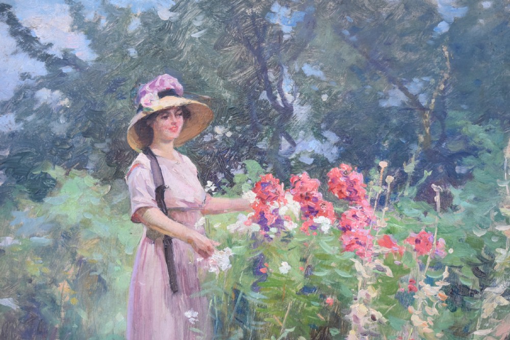 An oil painting depicting a woman wearing a straw hat and pink dress standing in a lush green garden, framed in an ornate gold giltwood frame. View II