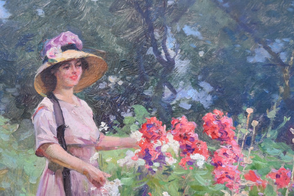 An oil painting depicting a woman wearing a straw hat and pink dress standing in a lush green garden, framed in an ornate gold giltwood frame. View IV