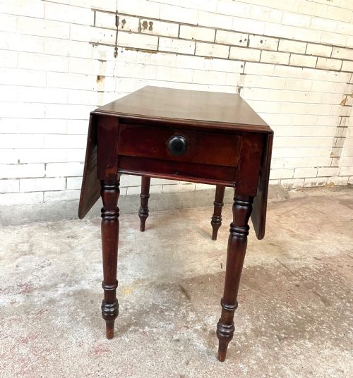 fig 1. A Victorian mahogany drop-leaf table with extended side flaps, a central drawer with a turned black knob, and four turned legs.
