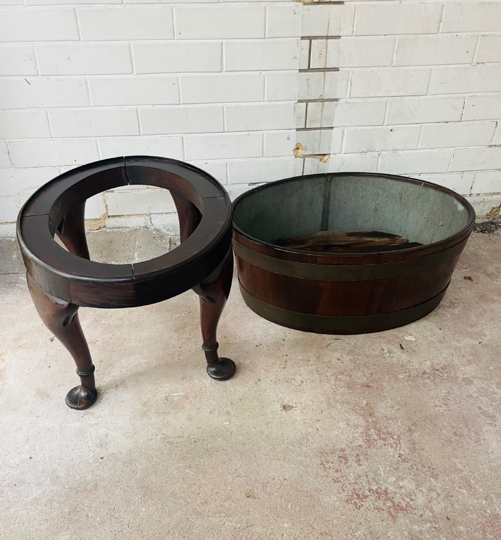 An oval brass-bound mahogany wine cooler on a stand with cabriole legs, pad feet, and lion mask handles. View IV