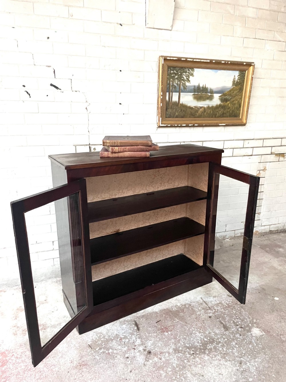 A low dark mahogany glazed bookcase featuring two glass panel doors, fluted side pilasters, and an integrated plinth base. View IV