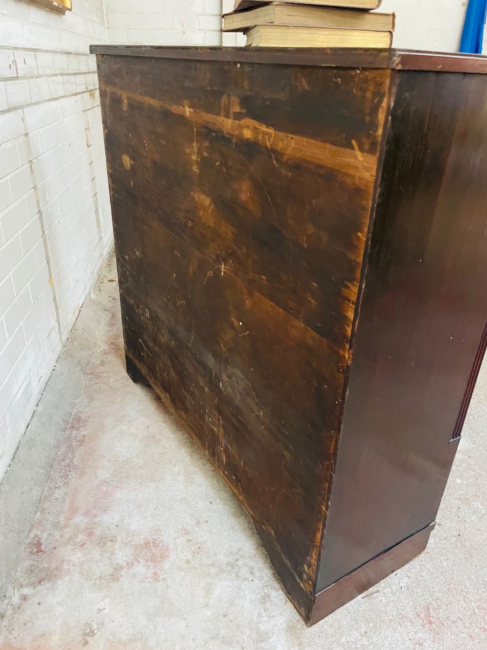 A low dark mahogany glazed bookcase featuring two glass panel doors, fluted side pilasters, and an integrated plinth base. View VIII
