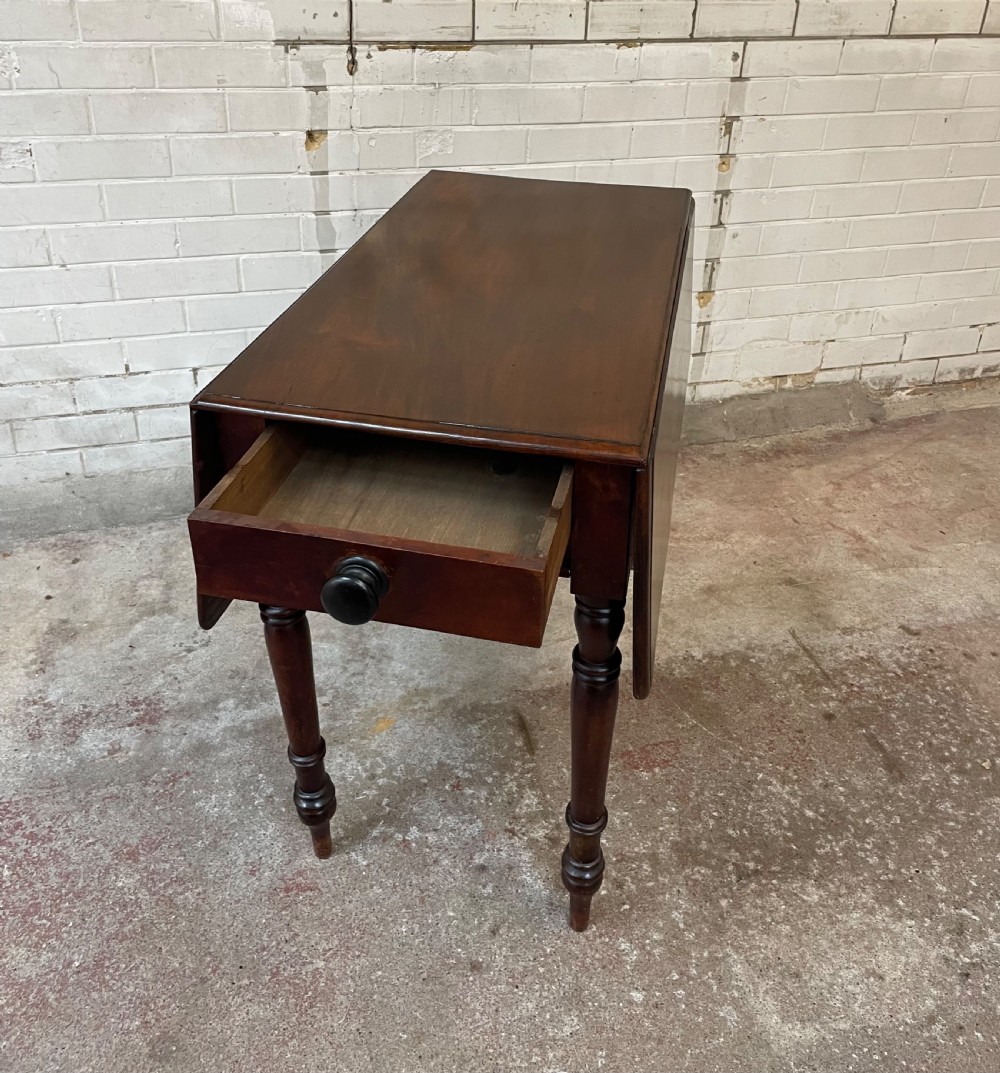 A Victorian mahogany drop-leaf table with extended side flaps, a central drawer with a turned black knob, and four turned legs. View III