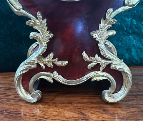 fig 1. A 19th-century Victorian mantel clock in the Louis XV style featuring a dark veneered balloon case with gilded metal foliage mounts and a white enamel dial.