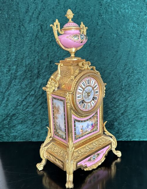 fig 1. A late 19th-century French gilt bronze mantel clock featuring hand-painted pink porcelain panels, an urn finial, and an enamel dial with Roman numerals.